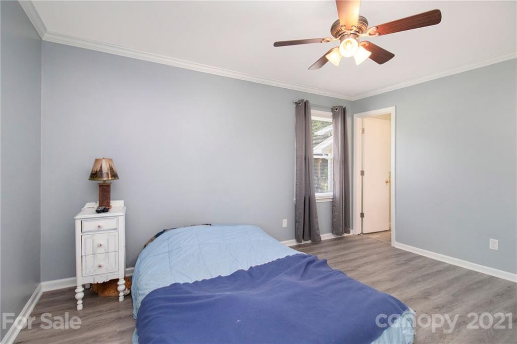 5702 Griffith Road Monroe, NC 28112 - Photo 22 of 35 a bedroom with a bed and a chandelier