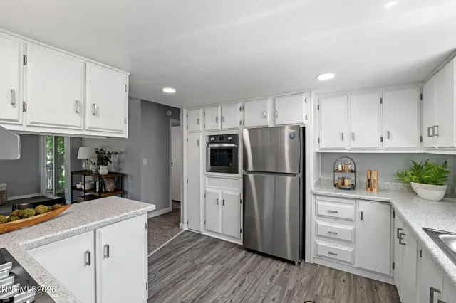 a kitchen with white cabinets and stainless steel appliances