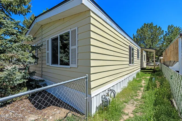 a view of a house with a small yard and wooden floor and fence