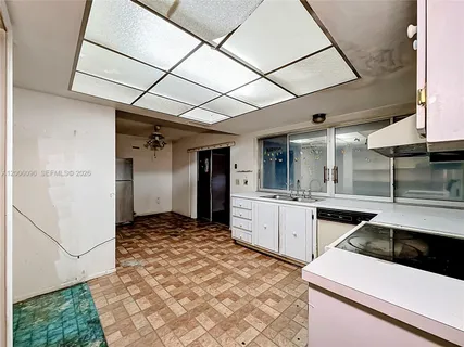a kitchen with a stove a refrigerator and cabinets