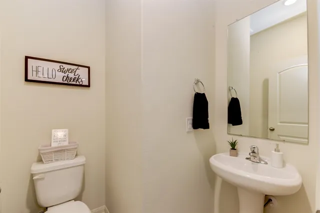 a bathroom with a toilet sink and mirror