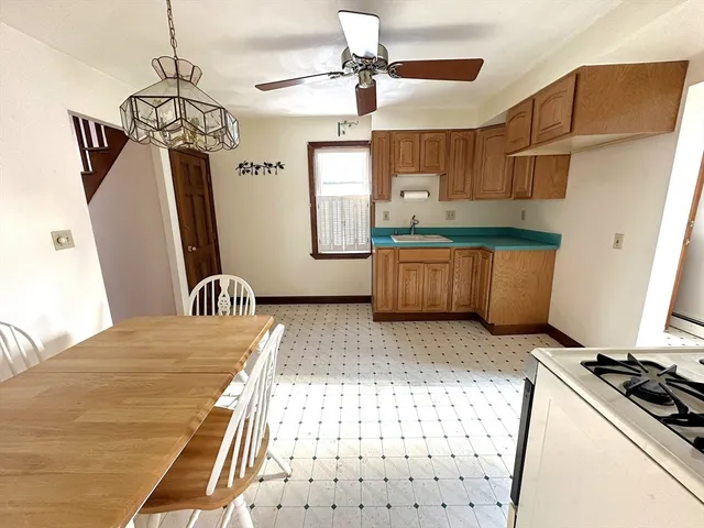 a kitchen with stainless steel appliances granite countertop a sink a stove a refrigerator cabinets and living room view