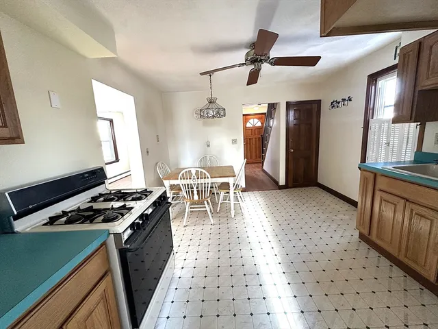 a kitchen with stainless steel appliances kitchen island granite countertop a stove a sink a refrigerator and cabinets