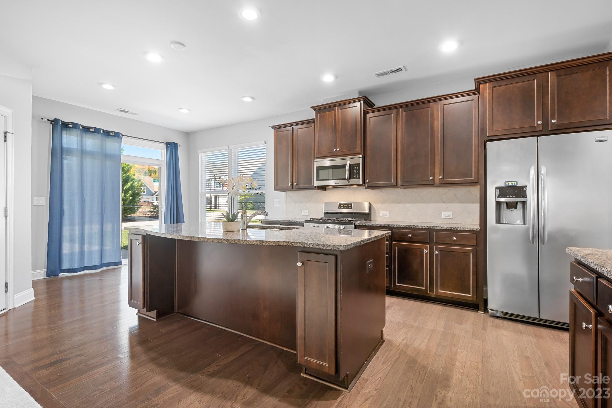 3329 Lucy Drive Monroe, NC 28110 - Photo 9 of 28 a kitchen with stainless steel appliances granite countertop a refrigerator a sink dishwasher a stove with wooden cabinets and floor