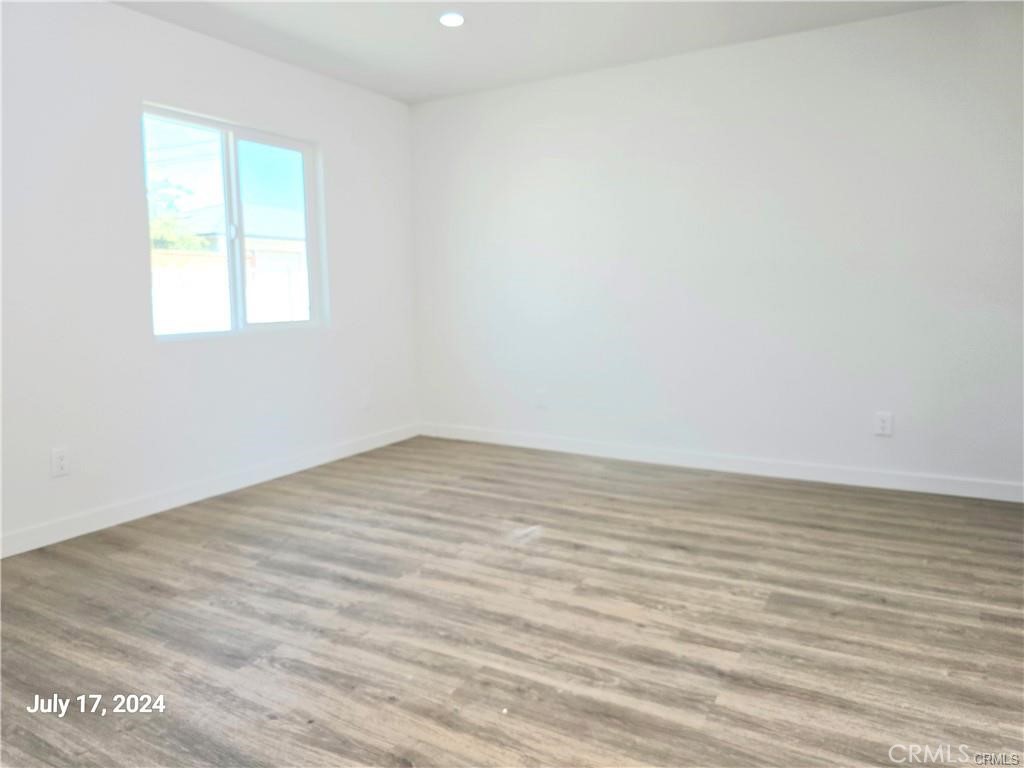 8734 Ramsgate Avenue Los Angeles, CA 90045 - Photo 4 of 9 a view of an empty room with wooden floor and a window