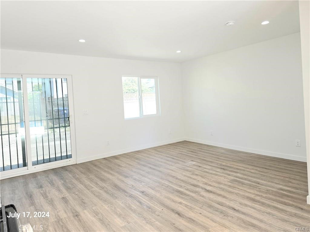 8734 Ramsgate Avenue Los Angeles, CA 90045 - Photo 5 of 9 an empty room with wooden floor and windows