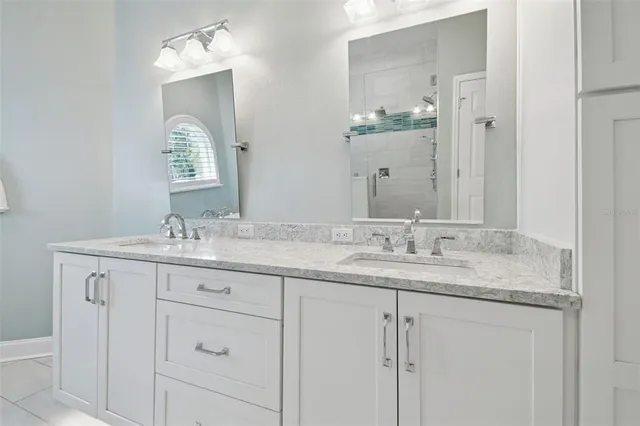 a spacious bathroom with a granite countertop sink and a mirror