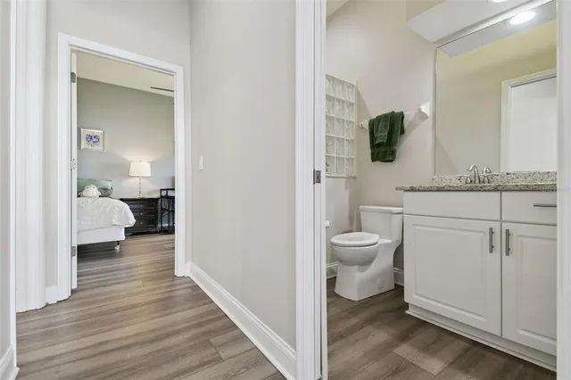 a bathroom with a granite countertop toilet sink and mirror