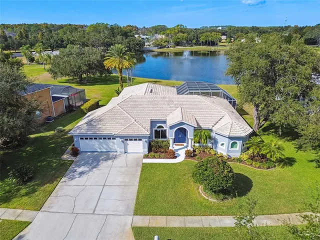 an aerial view of a house with swimming pool and a yard