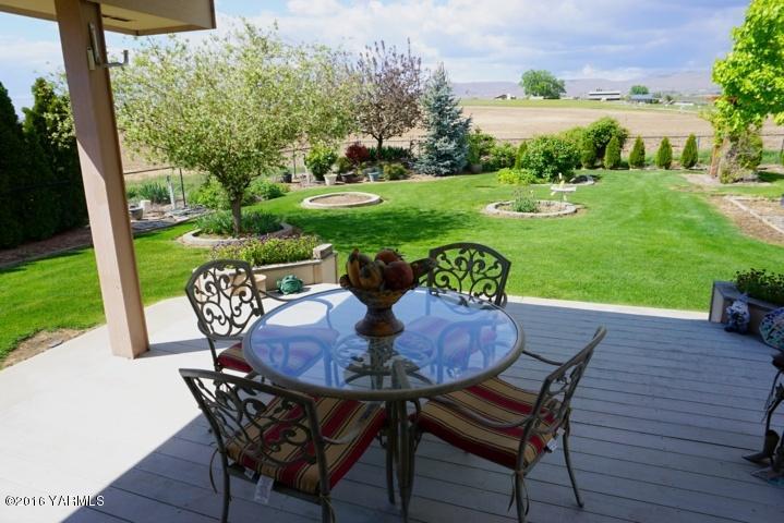 767 East Charron Road Moxee, WA 98936 - Photo 15 of 24 a view of a backyard with table and chairs potted plants and palm tree