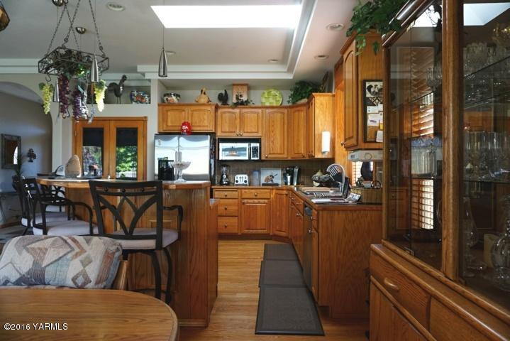 767 East Charron Road Moxee, WA 98936 - Photo 6 of 24 a kitchen with stainless steel appliances kitchen island granite countertop a table and chairs in it