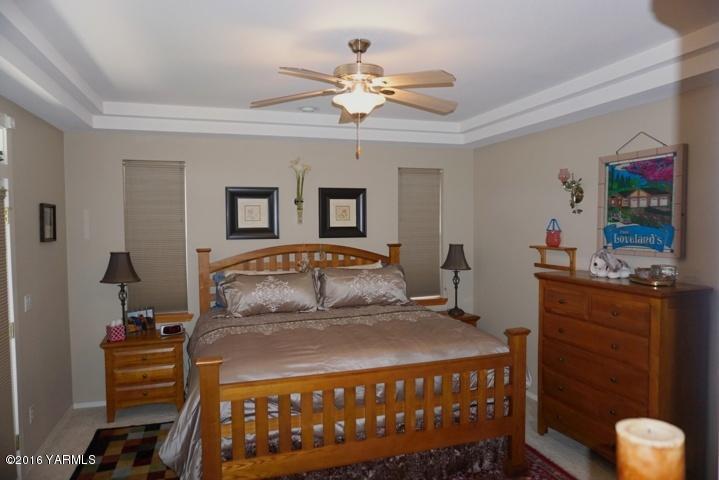767 East Charron Road Moxee, WA 98936 - Photo 9 of 24 a bedroom with a bed and a chandelier