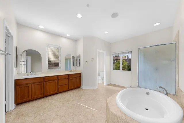 a bathroom with a tub sink shower and mirror