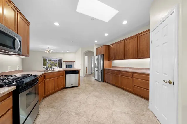a kitchen with stainless steel appliances granite countertop a stove a sink and a microwave
