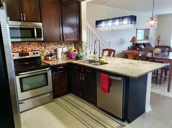 a kitchen with stainless steel appliances granite countertop a stove a sink and a microwave