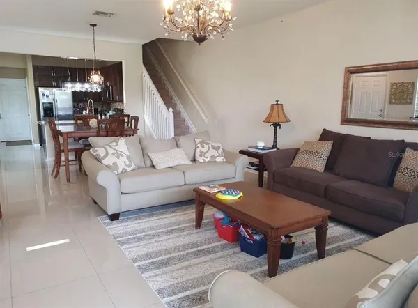 a living room with furniture a chandelier and a dining table