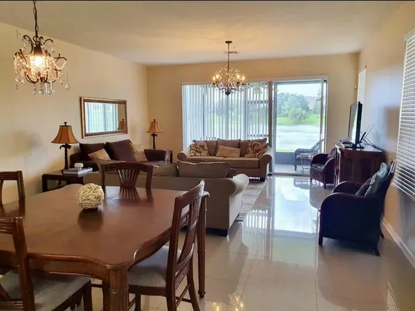 a view of a dining room with furniture a chandelier and wooden floor