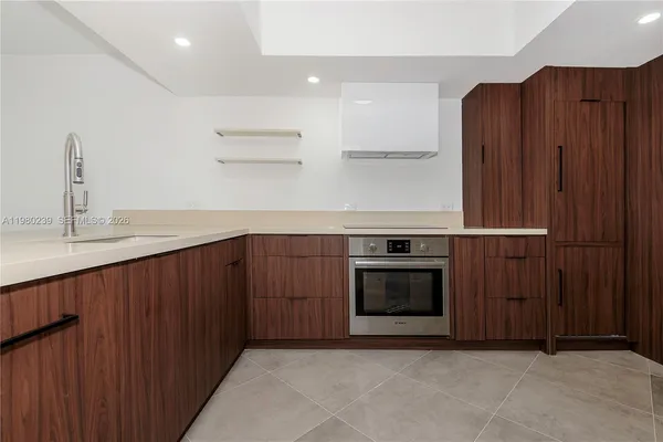 a kitchen with stainless steel appliances granite countertop wooden cabinets a stove top oven and oven