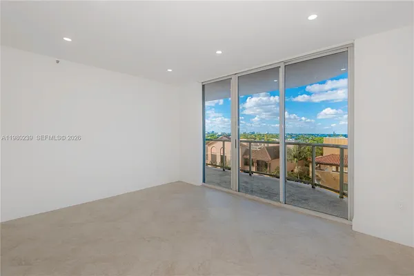 an empty room with sliding glass door and view of the room
