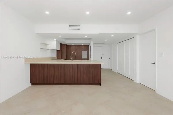 an empty room with wooden cabinet and entryway