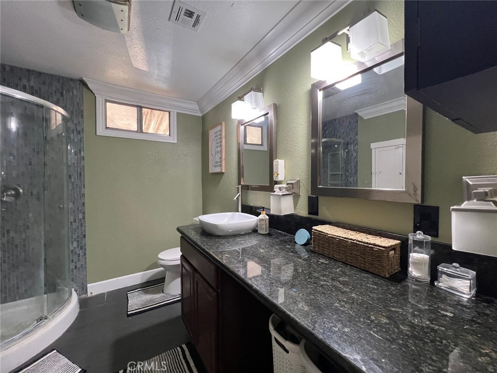 201 West Collins Avenue, Unit 40 Orange, CA 92867 - Photo 2 of 15 a bathroom with a granite countertop sink a toilet and shower