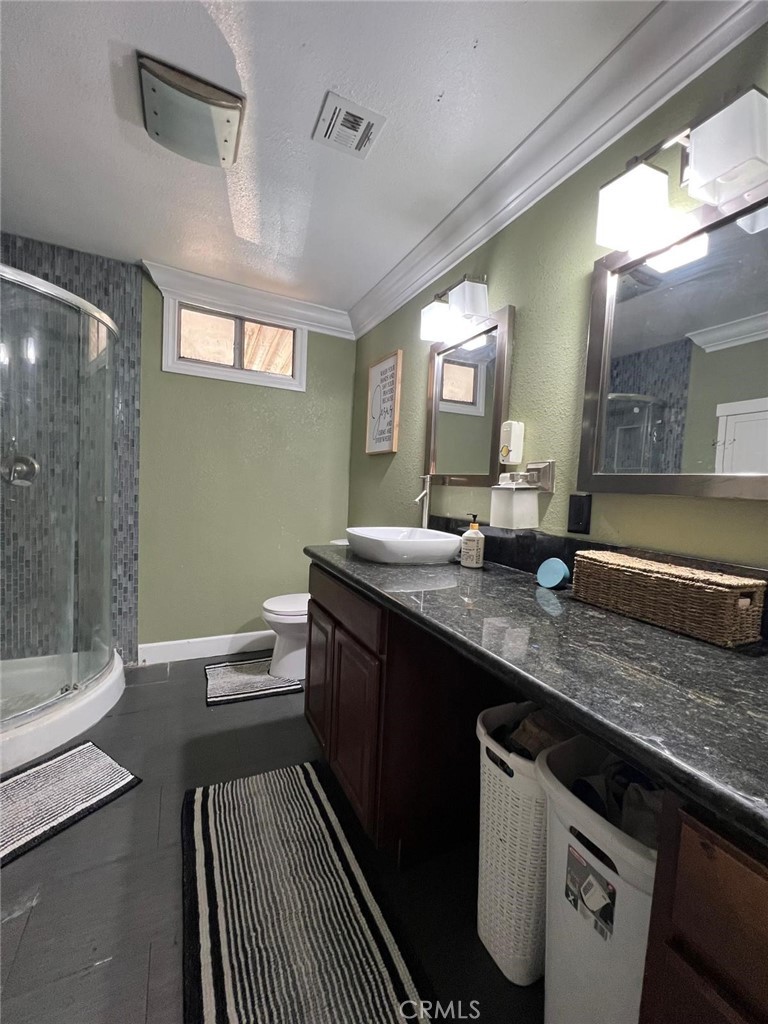 201 West Collins Avenue, Unit 40 Orange, CA 92867 - Photo 3 of 15 a large bathroom with a granite countertop sink a toilet a mirror and shower