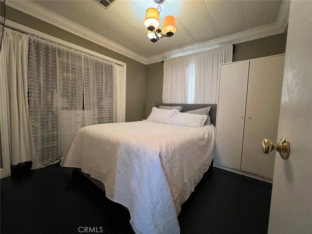201 West Collins Avenue, Unit 40 Orange, CA 92867 - Photo 5 of 15 a bedroom with a bed and a chandelier