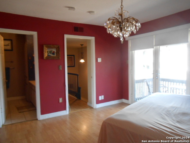 2300 Nacogdoches Road, Unit 118E San Antonio, TX 78209 - Photo 29 of 35 a bedroom with a bed and a chandelier