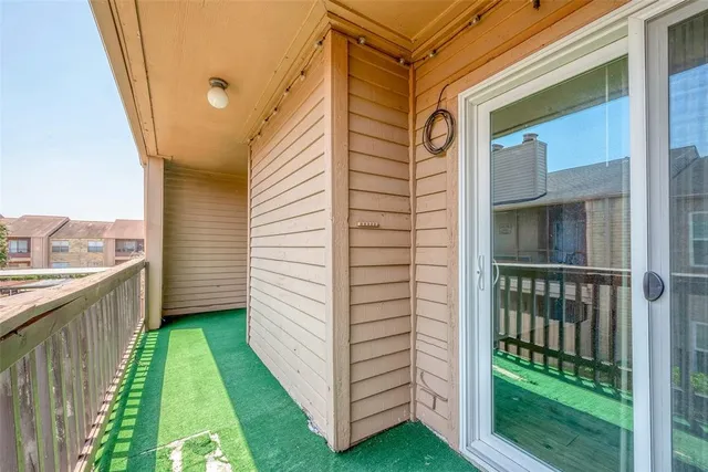 a view of a porch with a door and wooden floor