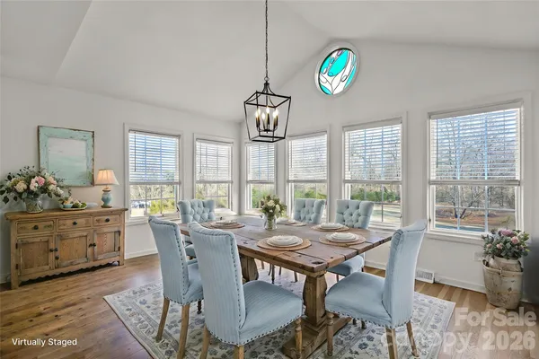 a view of a dining room with furniture a chandelier and wooden floor