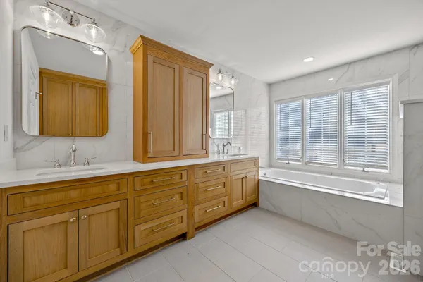 a spacious bathroom with double vanity and a mirror