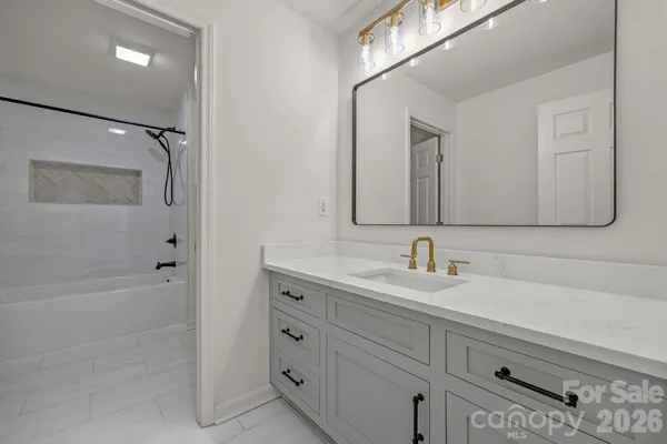 a bathroom with a bathtub a sink a vanity and a mirror