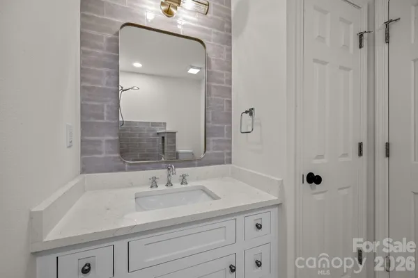 a bathroom with a sink vanity granite and shower