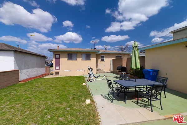 a view of a patio with table and chairs with wooden fence