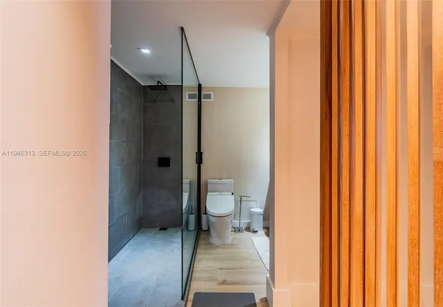 a bathroom with a granite countertop sink a toilet and shower