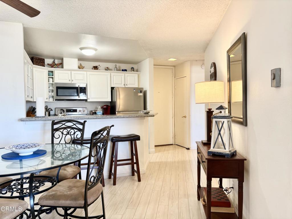 3101 Peninsula Road, Unit 312 Oxnard, CA 93035 - Photo 4 of 38 a view of a dining room with furniture and wooden floor