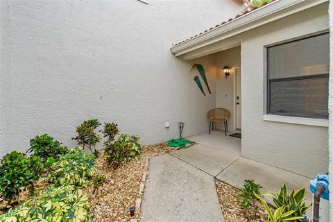 a front view of a house with a yard and a lot of potted plants
