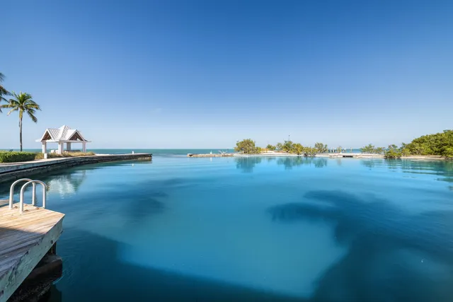 a kitchen with stainless steel appliances granite countertop a stove top oven a sink dishwasher a dining table and chairs with wooden floor