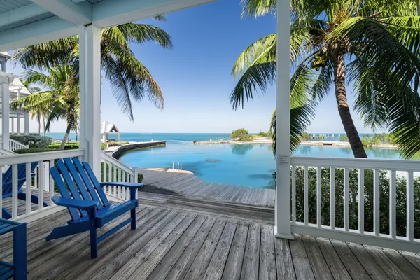 a view of a balcony with chairs and wooden floor