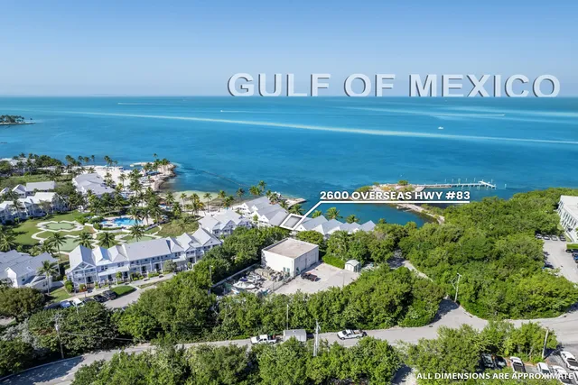 a white bath tub sitting in a bathroom with a swimming pool and outdoor space