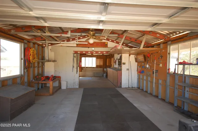 a front view of a house with a dirt yard and a large tree