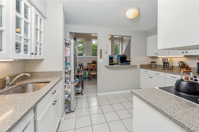 a view of a dining room with furniture one side kitchen view and wooden floor