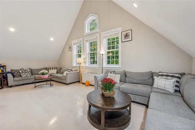 a living room with furniture a flat screen tv and a large window