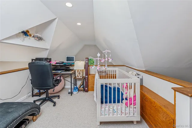 a view of a hallway with workspace and lounge chair