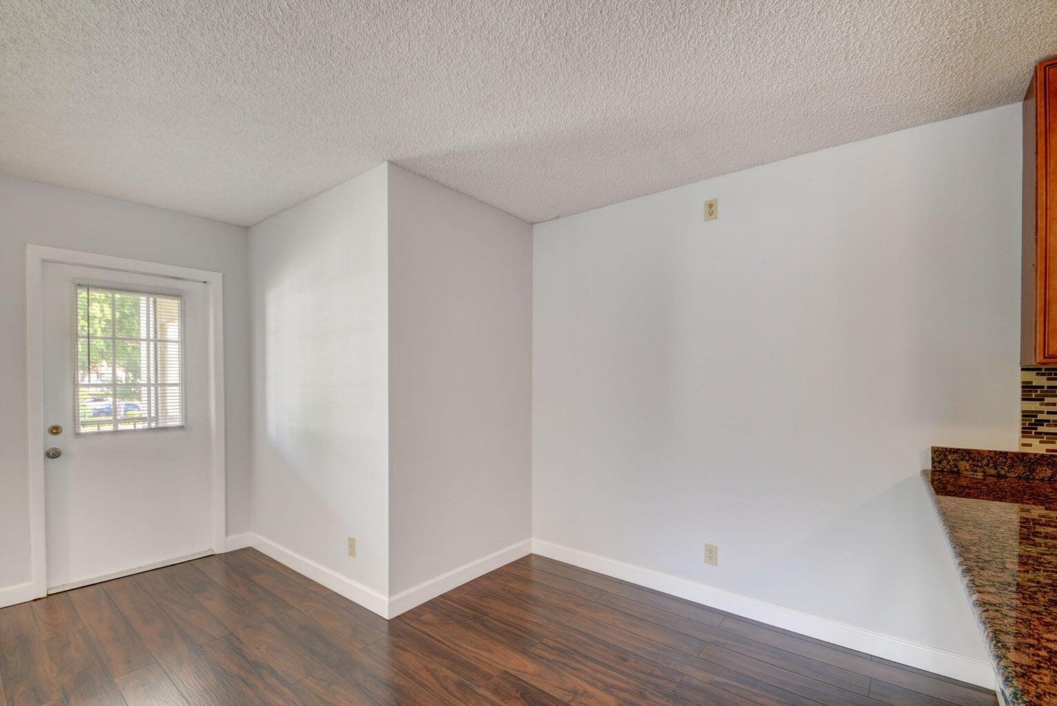 4844 Sable Pine Circle, Unit D2 West Palm Beach, FL 33417 - Photo 11 of 45 a view of an empty room with wooden floor and a window