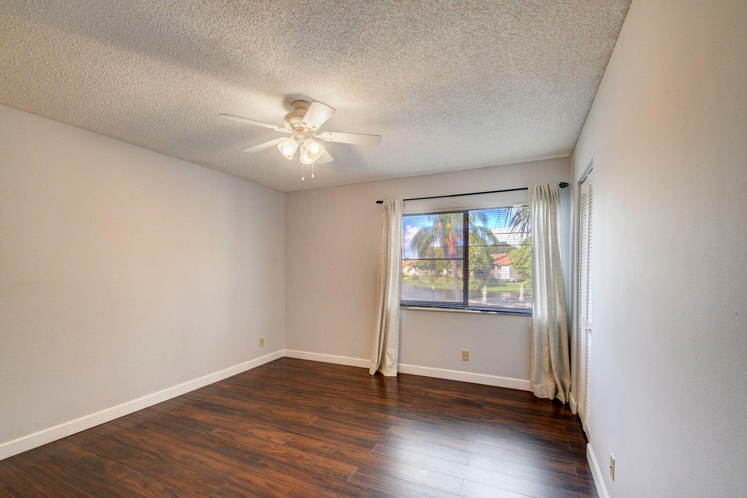 4844 Sable Pine Circle, Unit D2 West Palm Beach, FL 33417 - Photo 18 of 45 an empty room with wooden floor and windows
