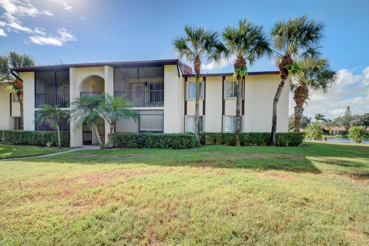 4844 Sable Pine Circle, Unit D2 West Palm Beach, FL 33417 - Photo 29 of 45 a front view of house and yard with green space