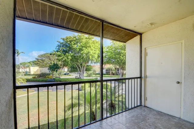 an empty room with wooden floor ceiling fan and windows