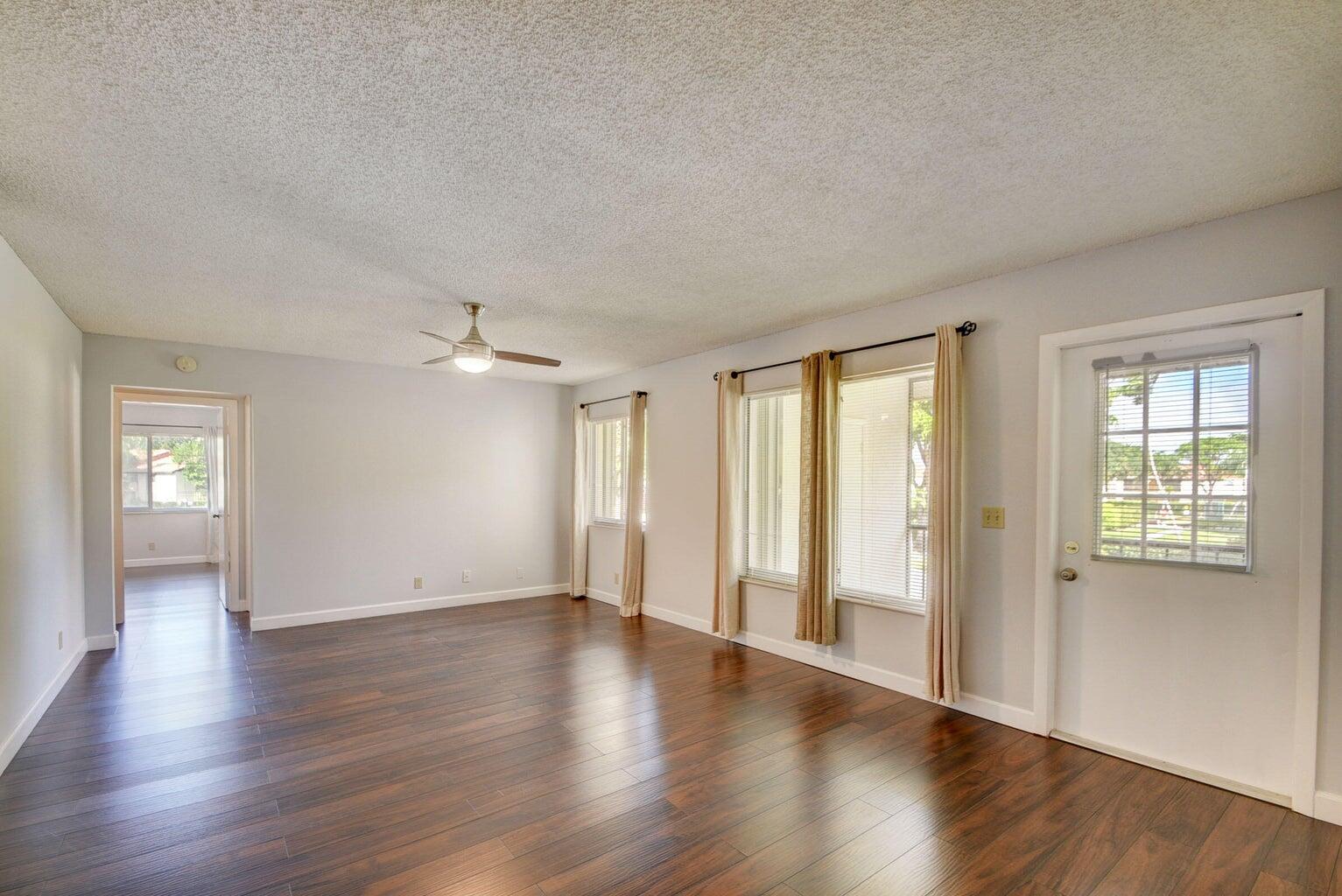 4844 Sable Pine Circle, Unit D2 West Palm Beach, FL 33417 - Photo 9 of 45 an empty room with wooden floor and windows