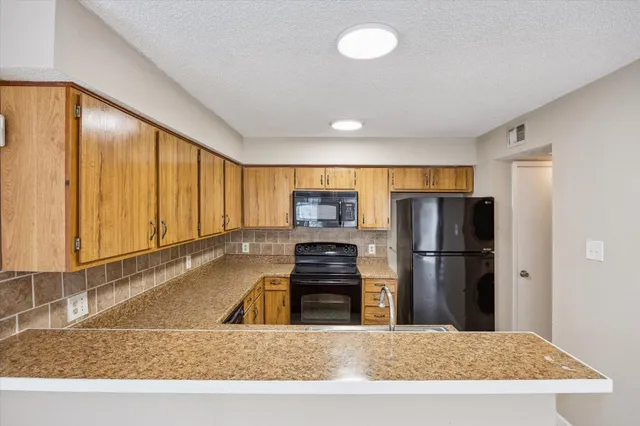 a kitchen with a refrigerator and a stove top oven